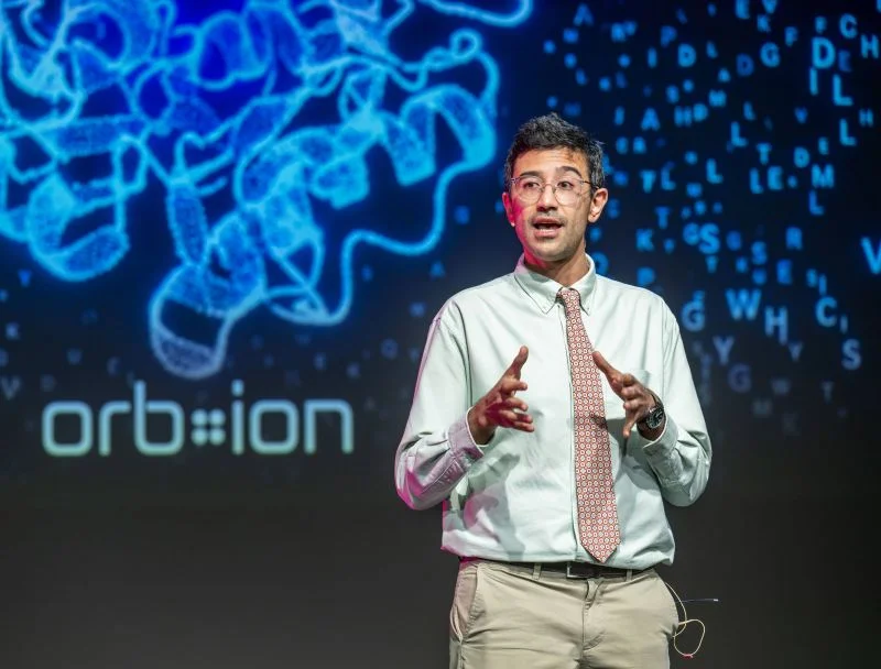 Çağlar Bozkurt presenting Orbion on stage at the Quantum Global Summit in Basel.